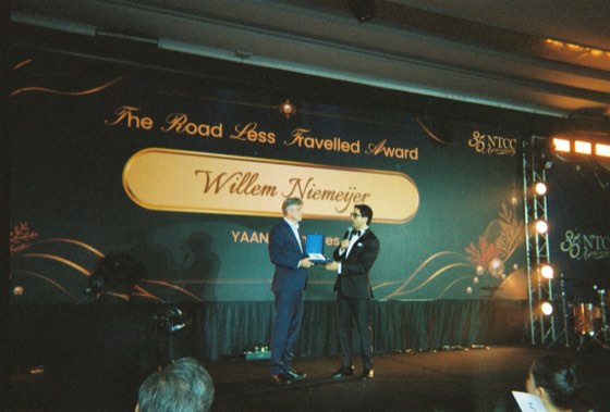 An award presented on stage, shot on film from the audience