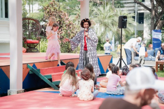 Children watching a storyteller on a garden stage