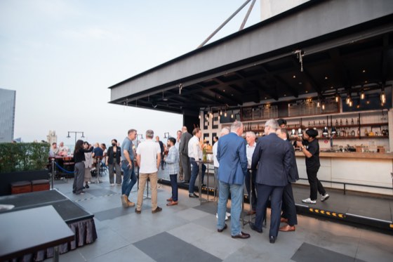 Guests gathering at a rooftop bar in the early evening