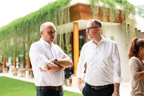 Two guests talking beside a planted pavilion